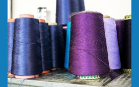 Colorful thread reels set up for sewing machine, textile industry factory concept